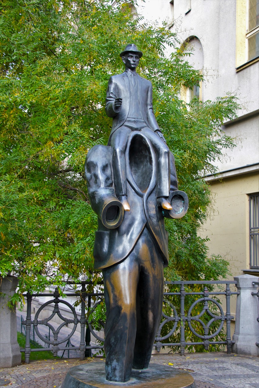 Franz Kafka statue found in Prague, man on shoulders of another man.